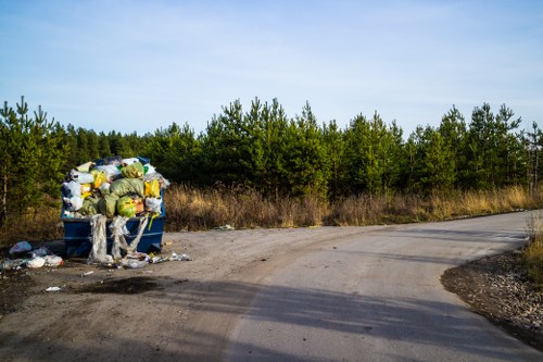 Havering Skip Hire branded skip beside a driveway with operatives preparing for work